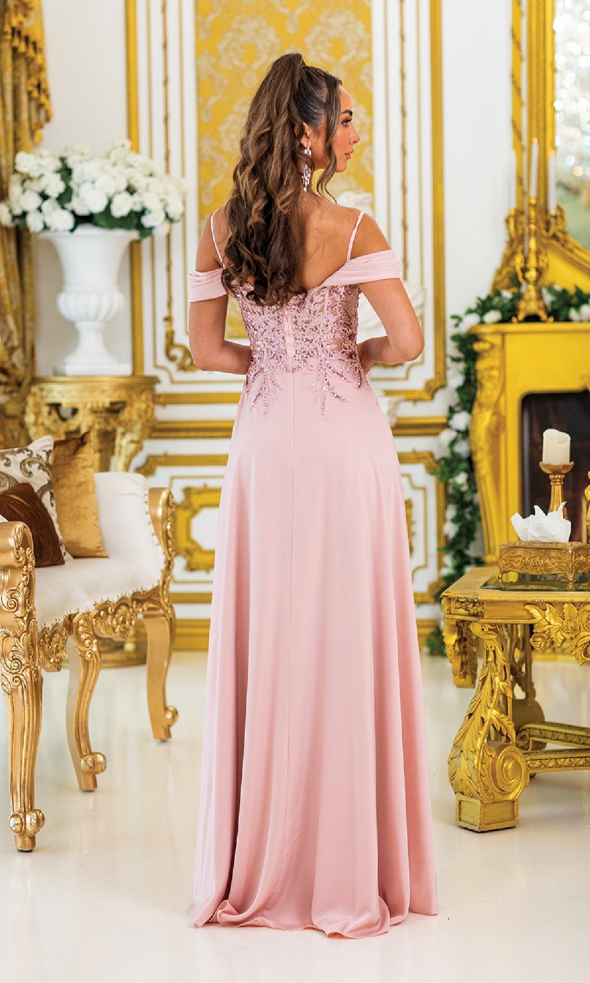 A woman in the Lace-Corset Long Prom Dress: Dancing Queen 4474 stands facing away in an ornate room with gold and white décor.